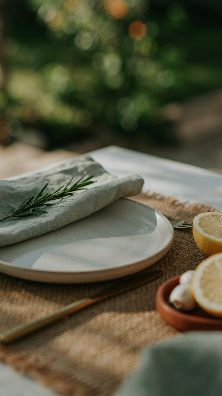 A close up shows an elegant outdoor place setting with textured placemat and plate.