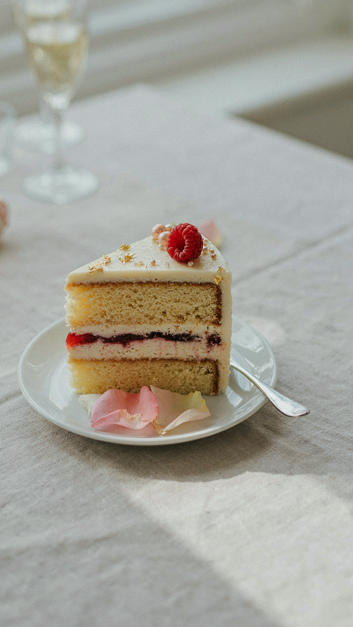 A close-up of a perfectly crafted slice of wedding cake on a plate.