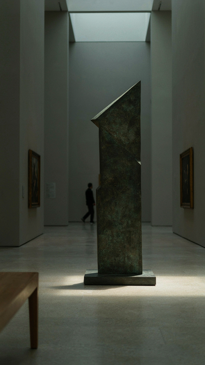 A brightly lit sculpture in a dimly lit museum commands attention.
