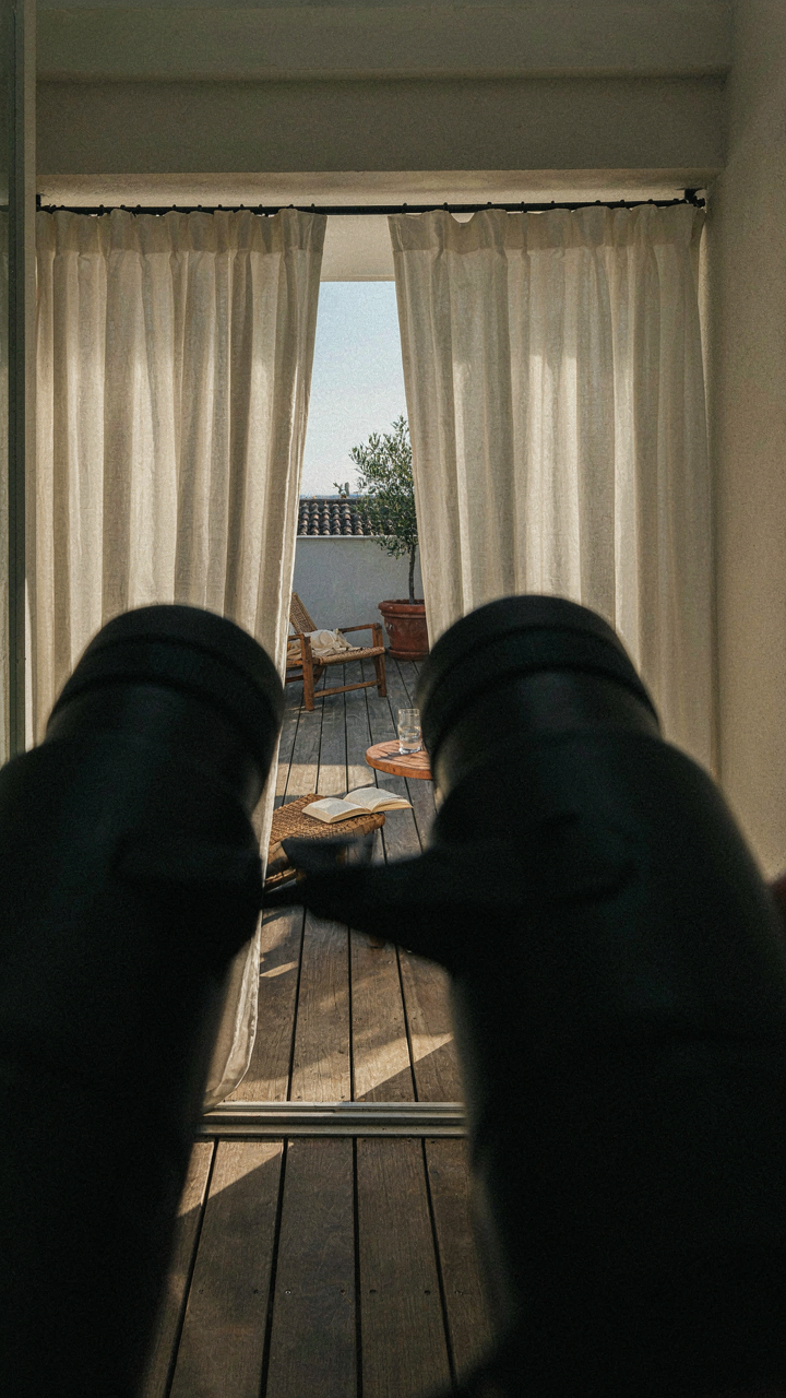 Binoculars point at a patio, but outdoor curtains for patio block the view.