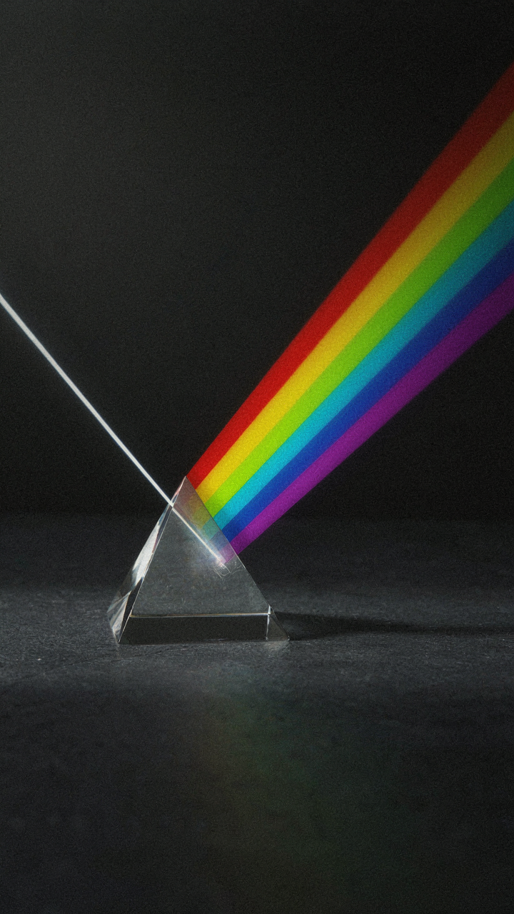 A prism separates white light into a colorful rainbow.