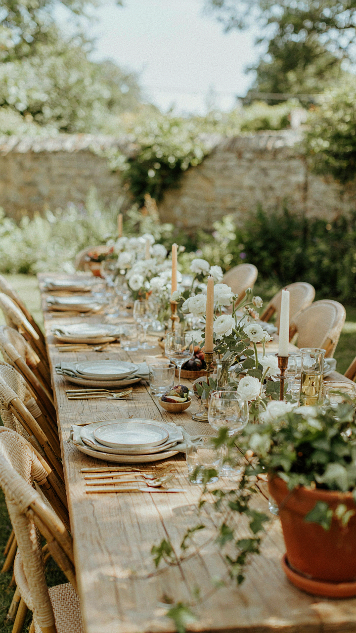 An outdoor dinner table is set perfectly with everything in order.
