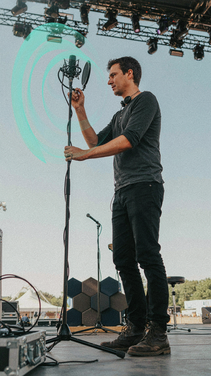 A sound engineer sets up equipment for an outdoor concert.