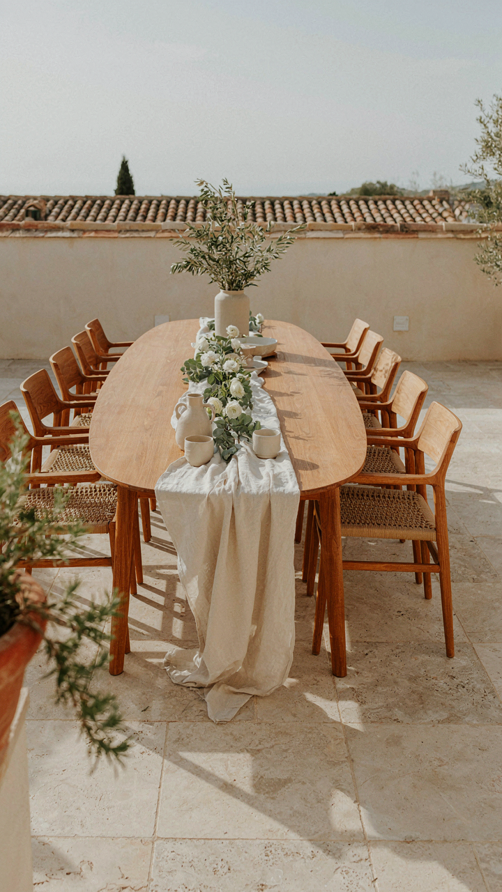 An oval-shaped outdoor dining table with chairs on a patio.