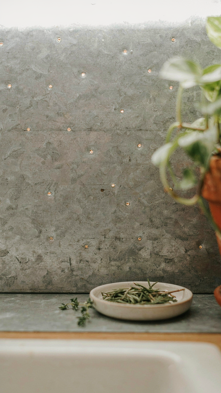 A rustic, textured metal sheet serves as a kitchen backsplash.