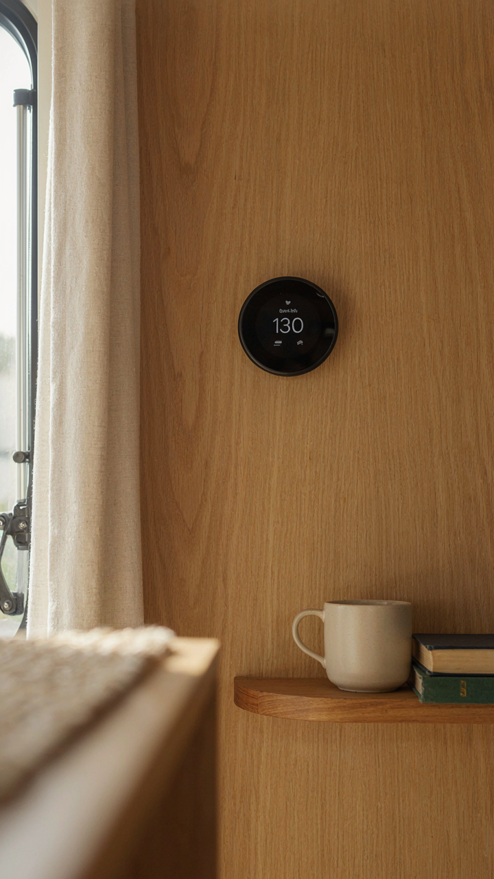 A smart thermostat displays the ideal temperature in a camper interior.