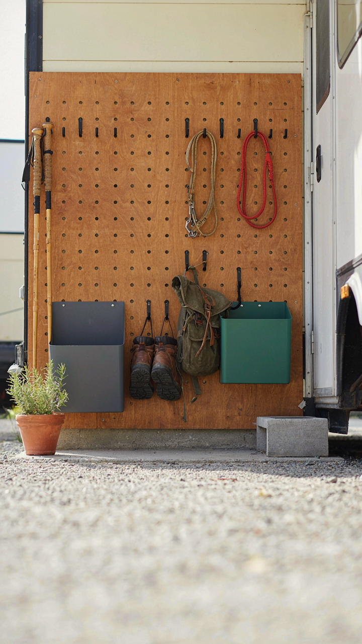 Labeled bins and hooks near an RV door for quick access to gear.