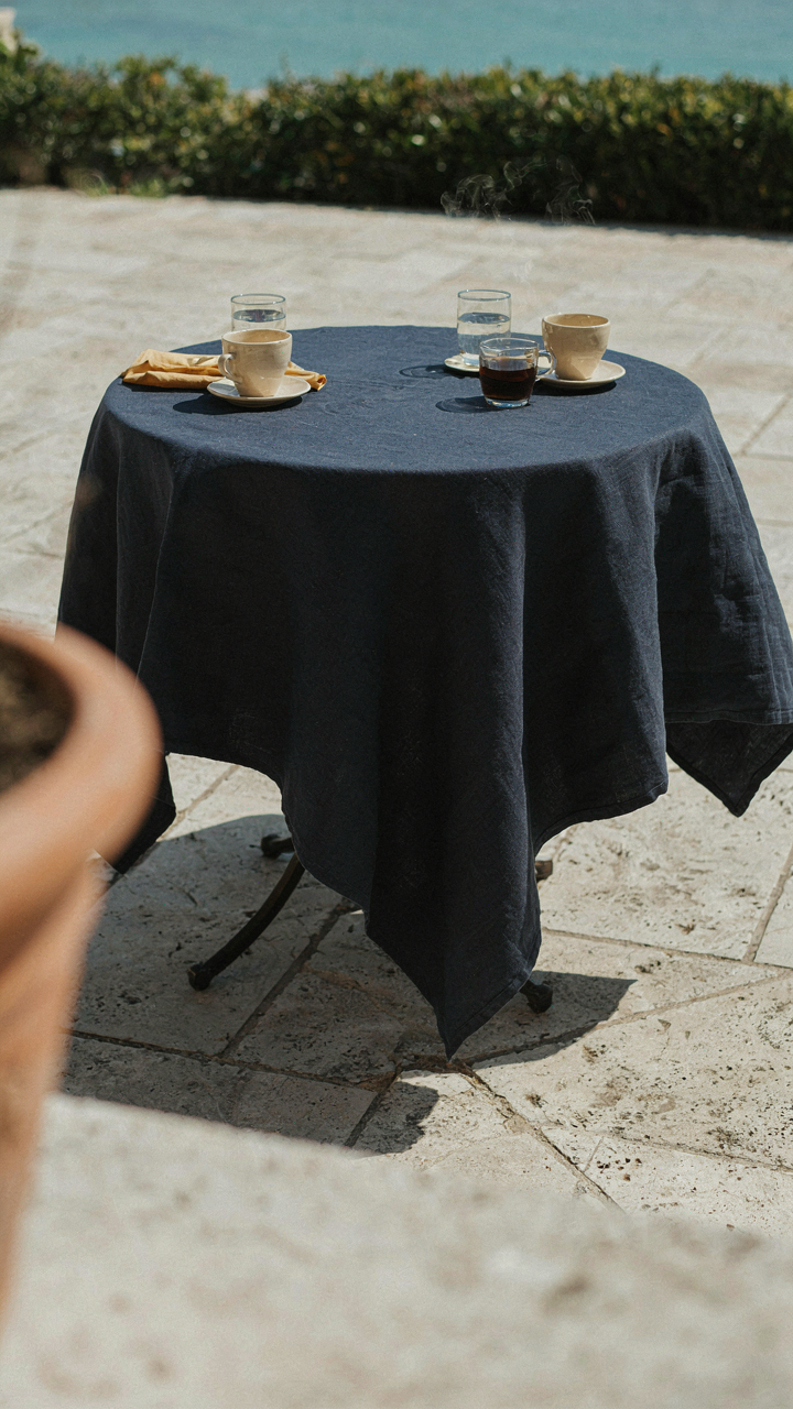 A dark navy blue tablecloth on an outdoor table in bright sunlight.
