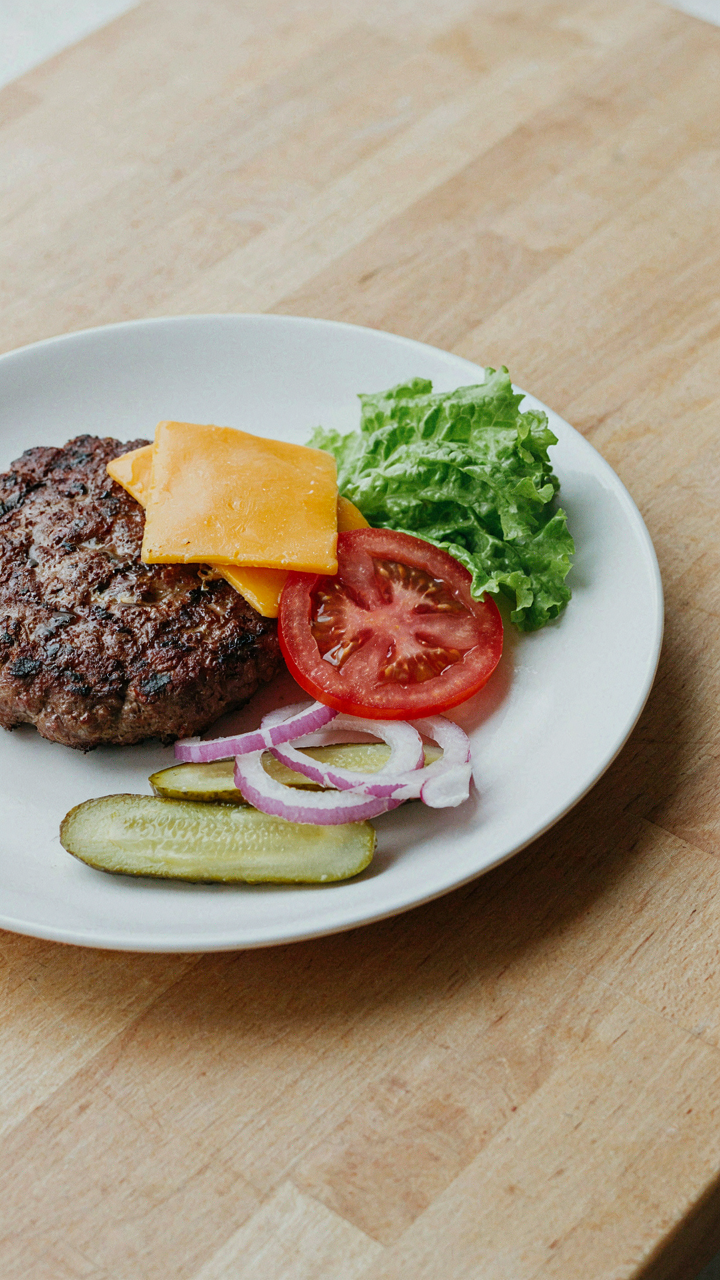 A clean plate has a few carefully chosen, perfectly portioned burger bar toppings left.