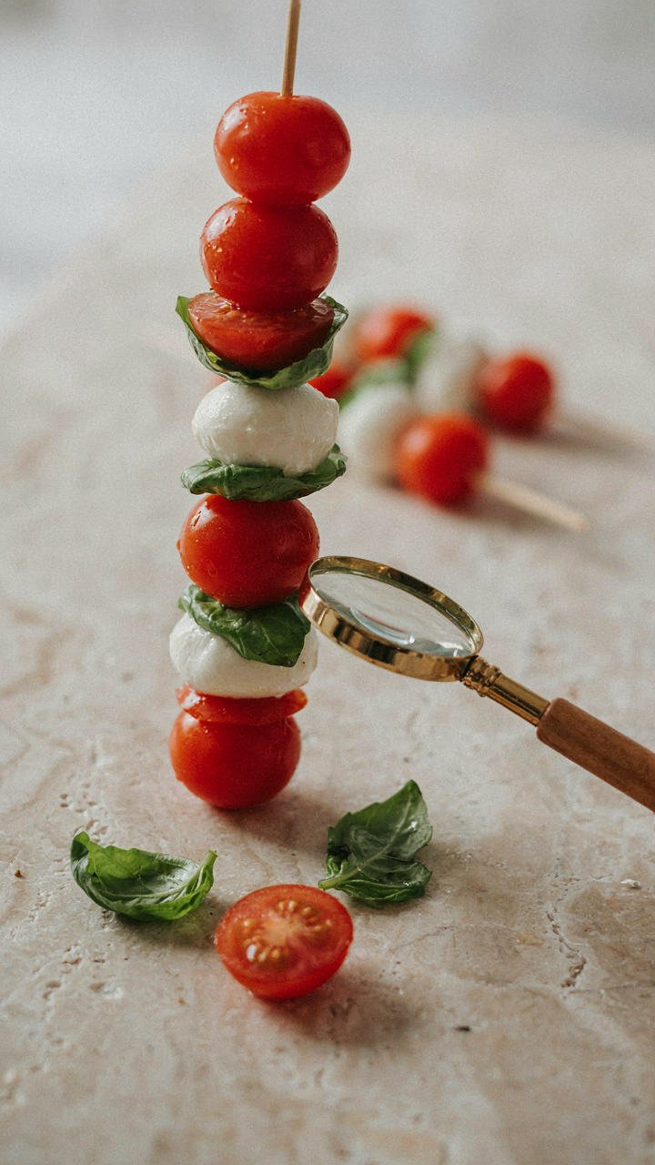 A perfect skewer with tomato, mozzarella, and basil, viewed closely.