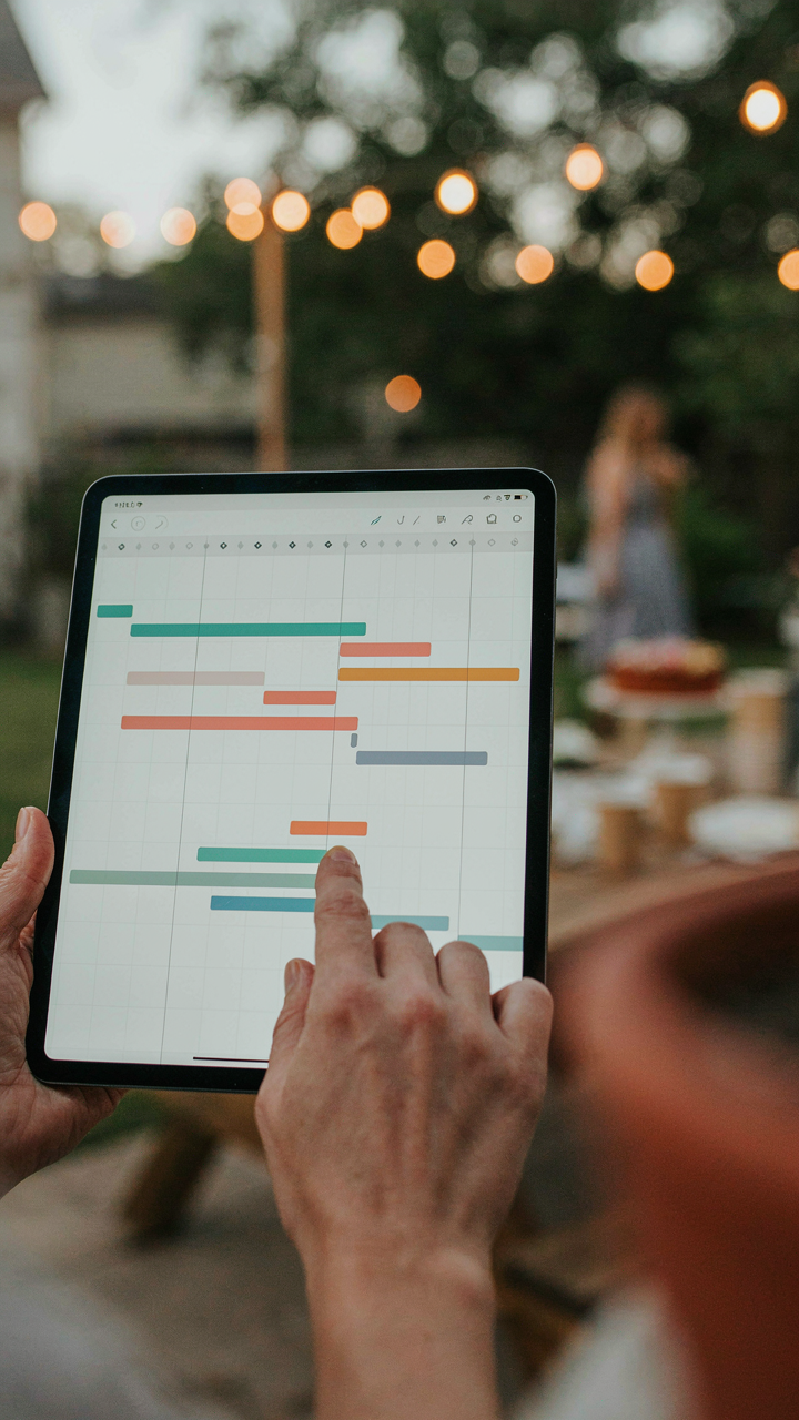 A project management chart on a tablet guides party setup tasks.