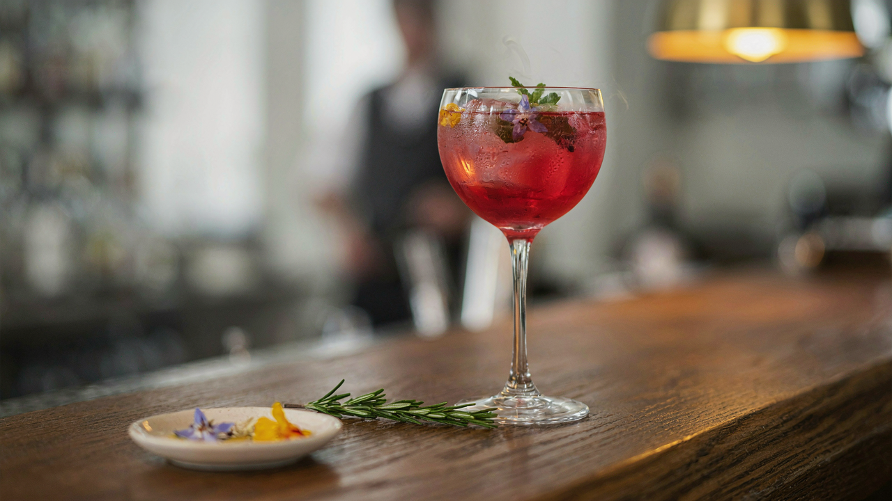 A colorful cocktail with decorative ice cubes, made with flowers and herbs.