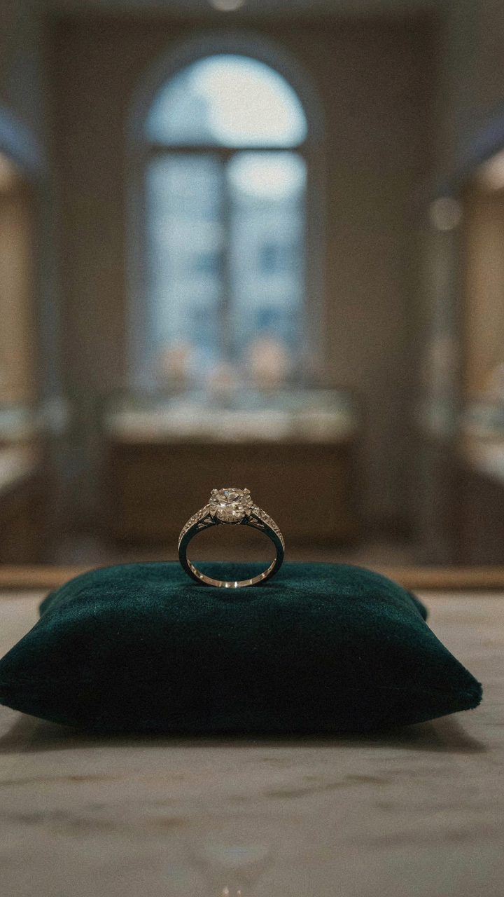 A single diamond ring on velvet in a luxury store.
