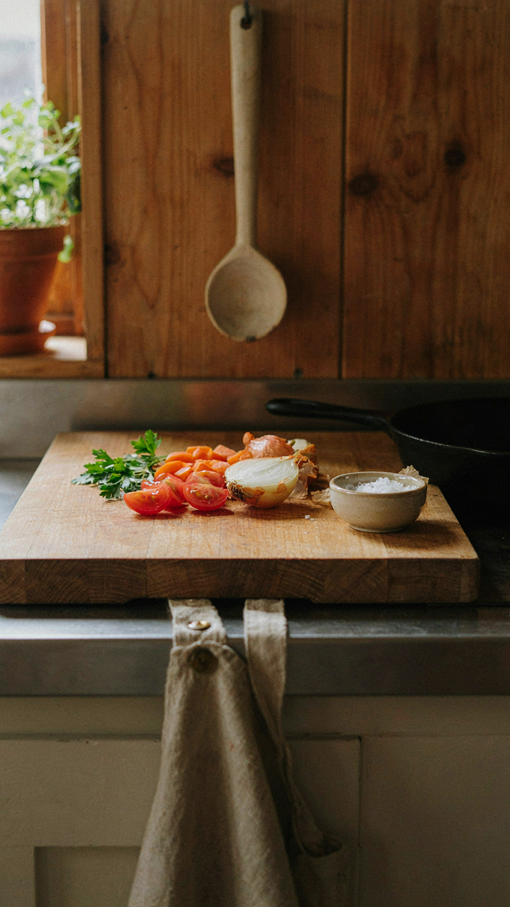 A neat camp kitchen with a wooden cutting board and a hand-carved spoon.
