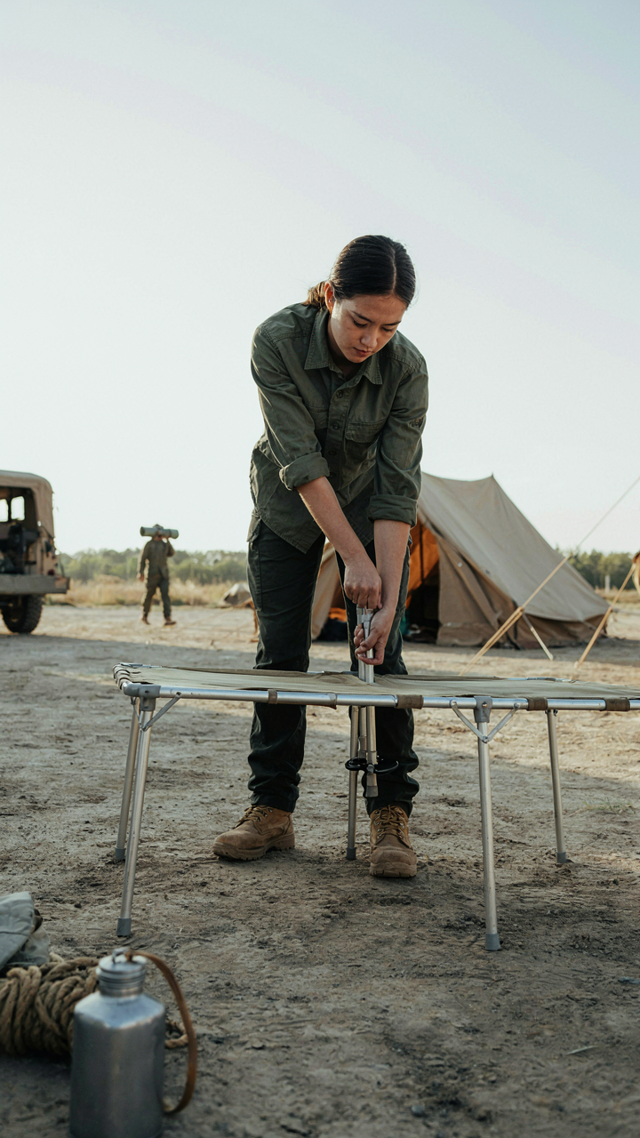 A person quickly sets up a diy camp table with smooth movements in a field camp.