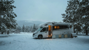 An RV is parked in the snow with diy rv skirting around its base.