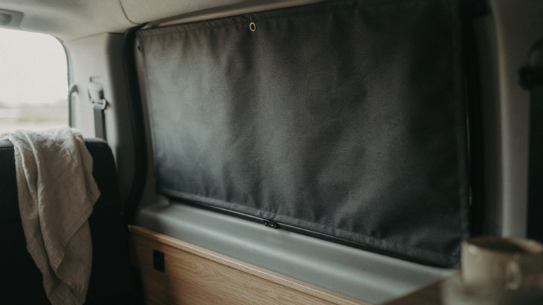 Custom diy van window covers perfectly block sunlight in a clean camper van.