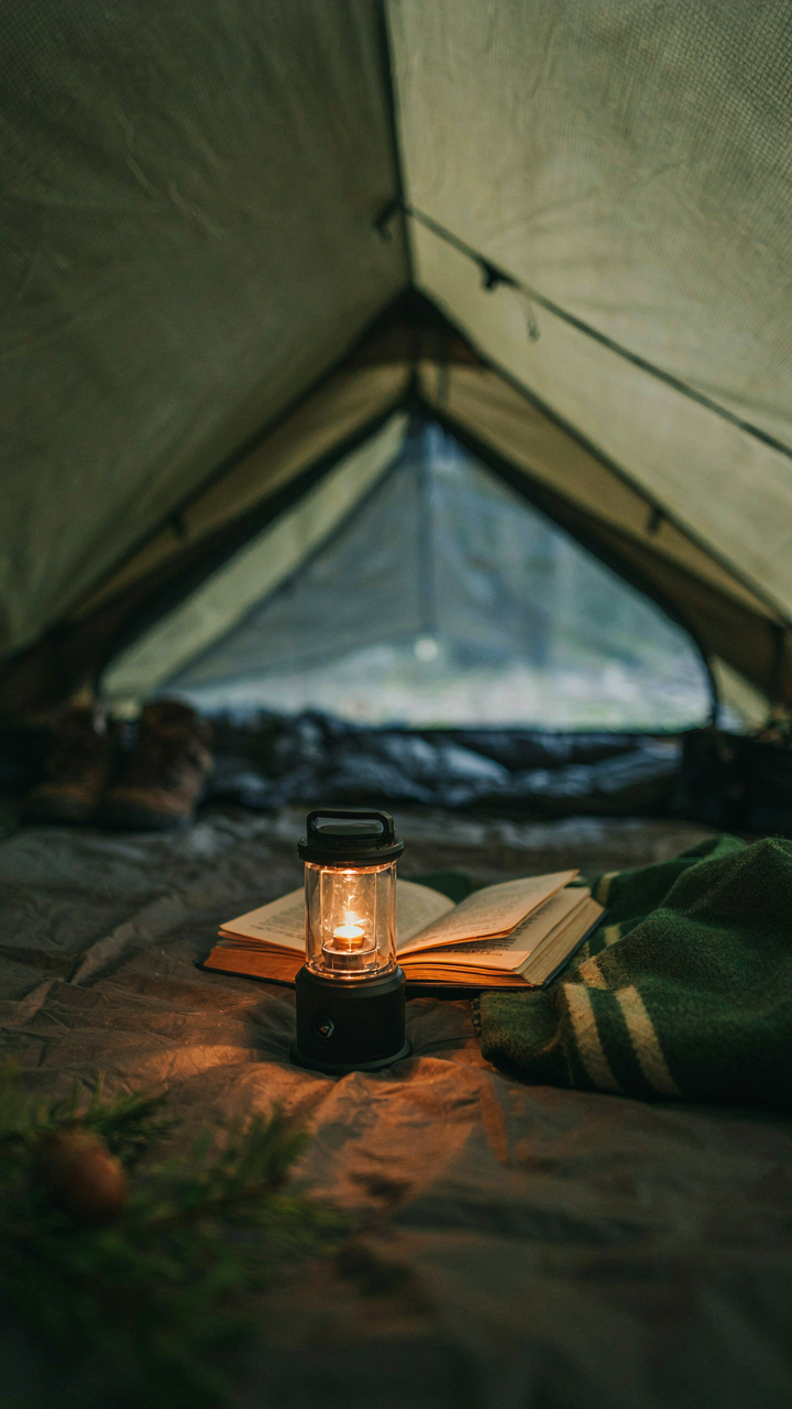 A small lamp makes a cozy tent glow orange.