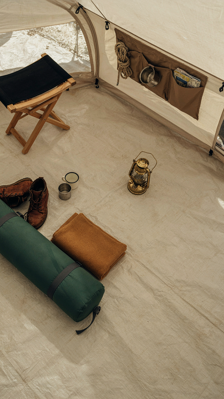 A top-down view of a canvas tent with space-saving furniture and storage solutions.
