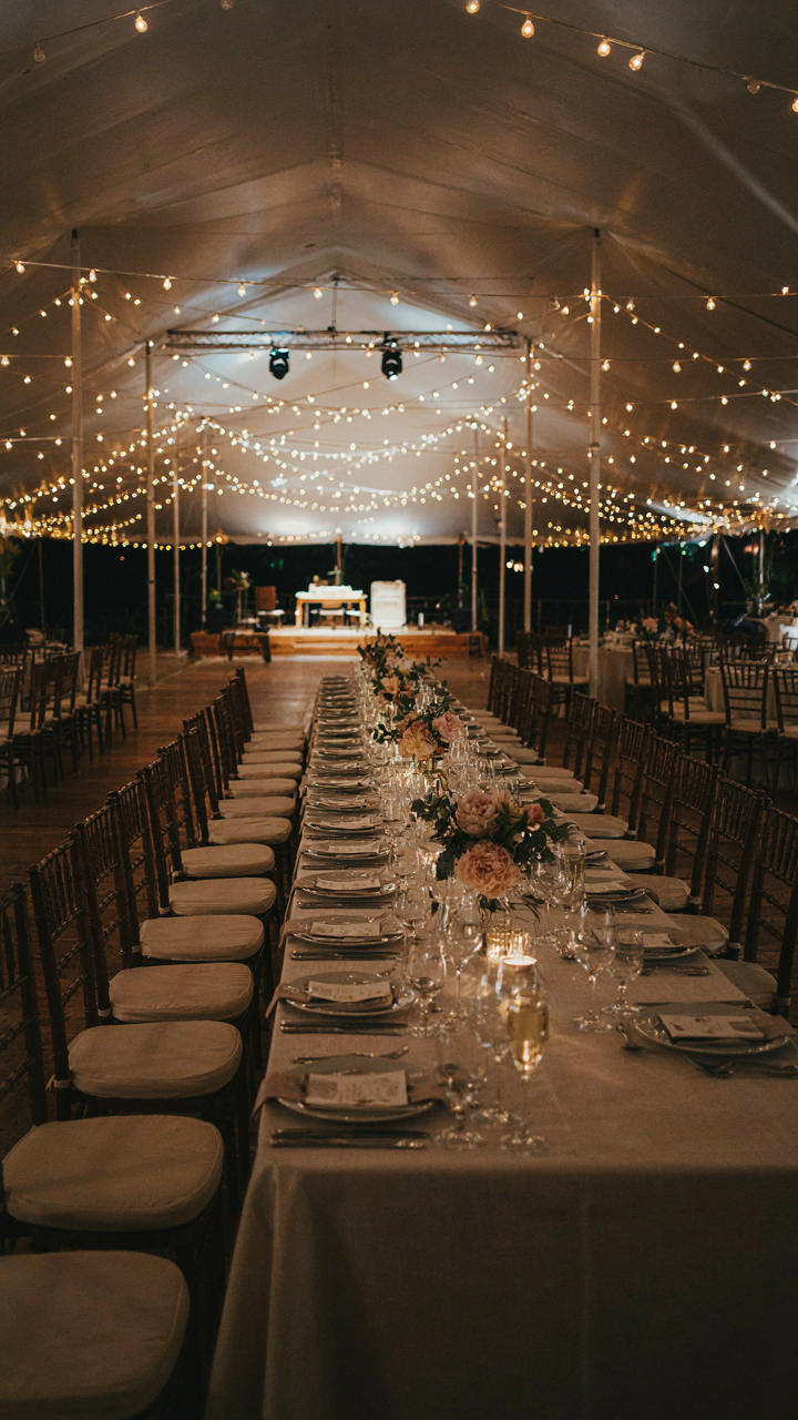An elegant event tent at night with professional, layered lighting.
