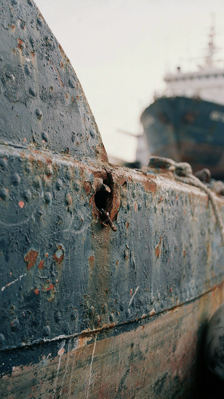 A detailed close up of a ship's hull with a small, visible breach.