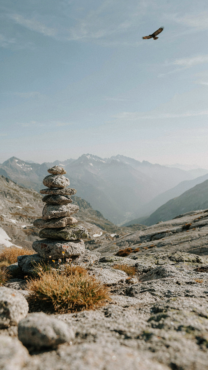 A perfectly balanced stack of rocks forming a tall cairn in nature.