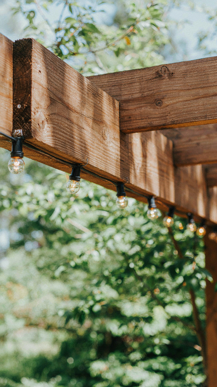 A sturdy pergola beam with carefully secured string lights.