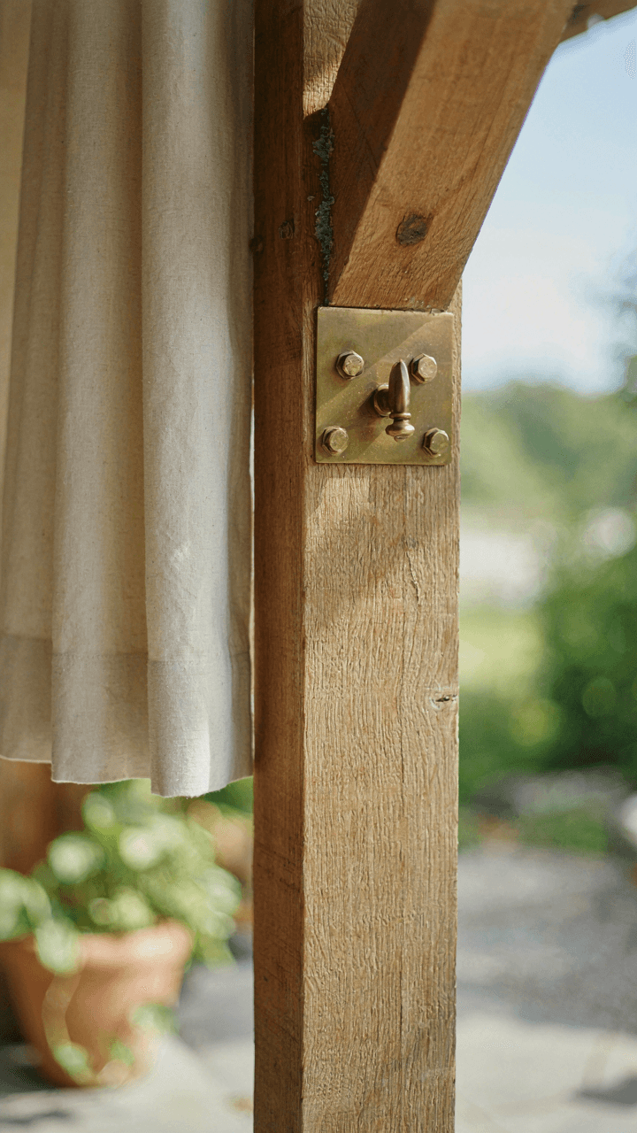 A strong metal bracket holds an outdoor curtain rod to a beam.