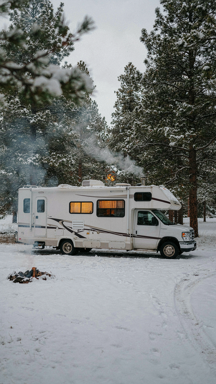 An RV in snow with internal RV window insulation visible.