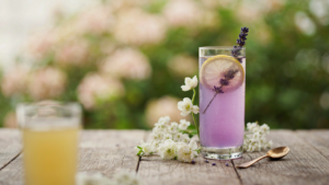 A refreshing lavender lemonade mocktail in a tall glass with lemon and lavender garnish.