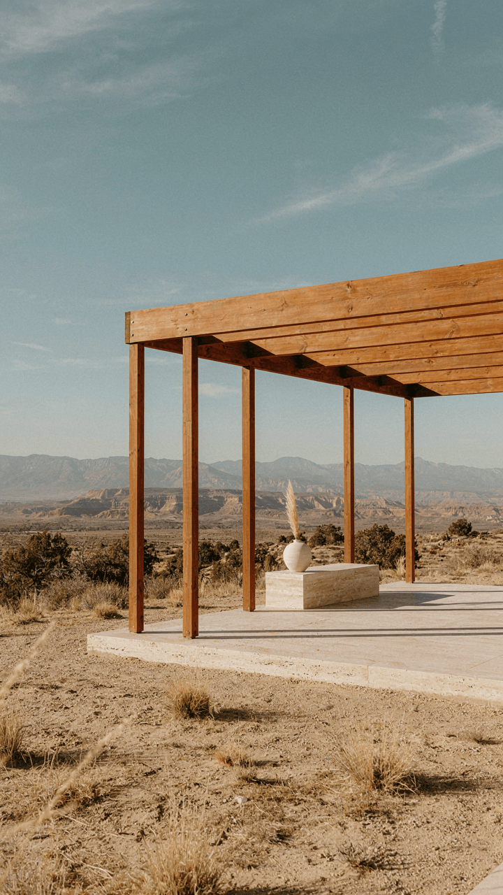 A modern pergola with simple lines stands against a dramatic natural landscape.