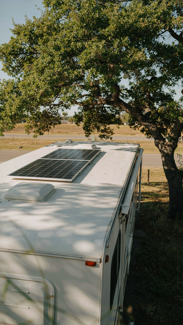 A camper trailer solar panel is angled perfectly in the morning sun.
