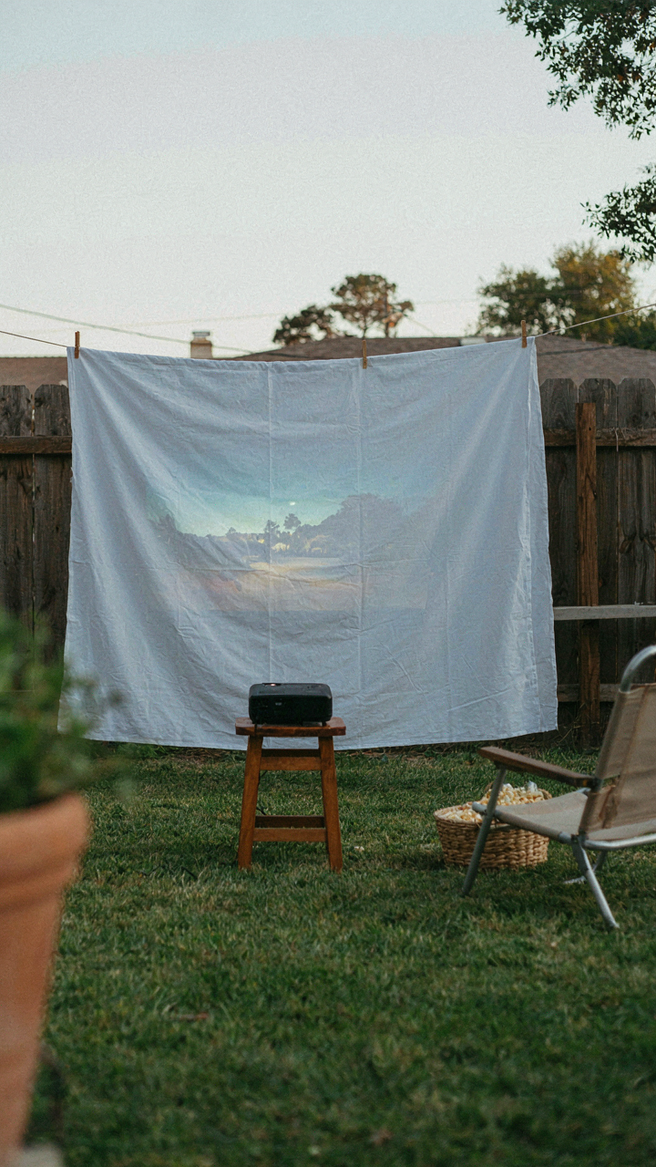 A white sheet on a clothesline is a simple movie screen.
