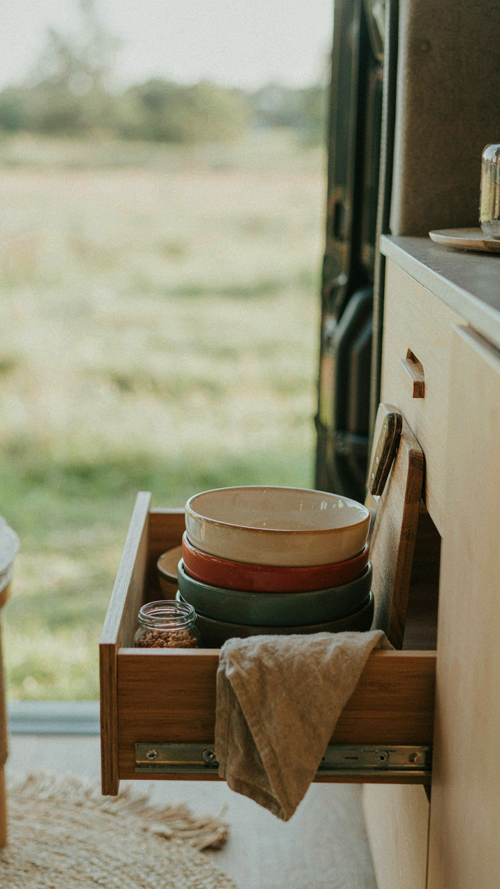 Clever storage with nested items and a pull-out shelf in a small van.