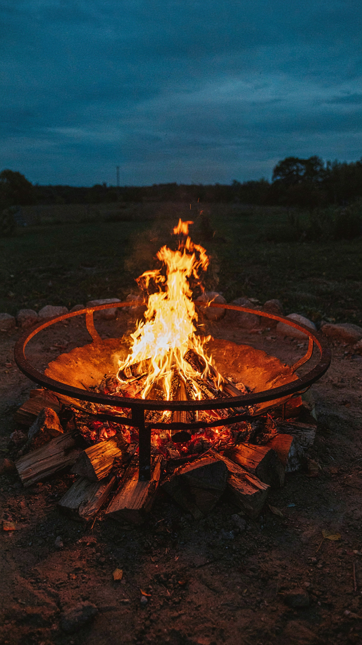 A campfire shows different zones of heat for cooking.