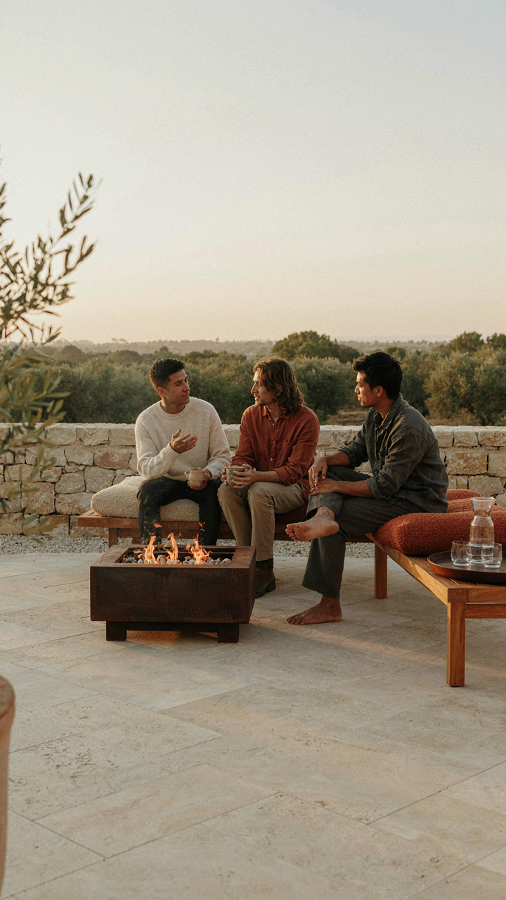 A simple outdoor lounge with a fire pit encourages easy conversation among guests.