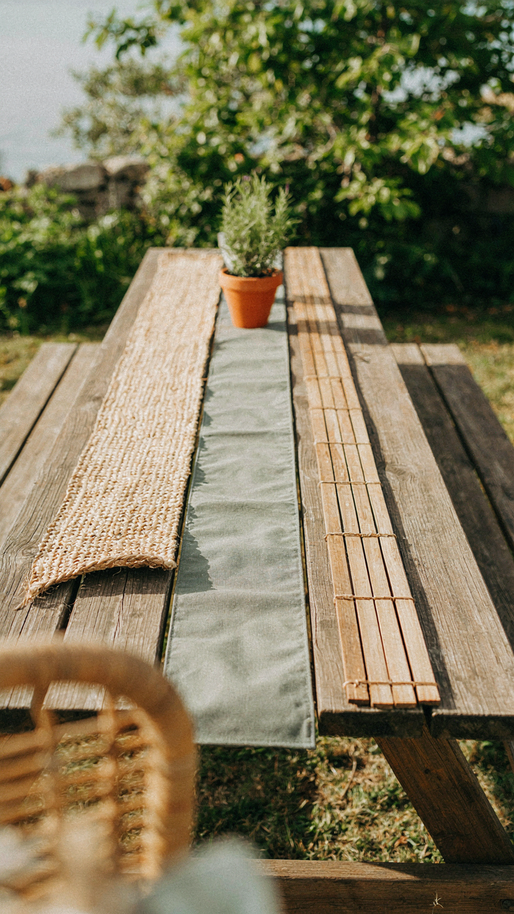 Different material table runners, like seagrass and wood slats, on an outdoor table.