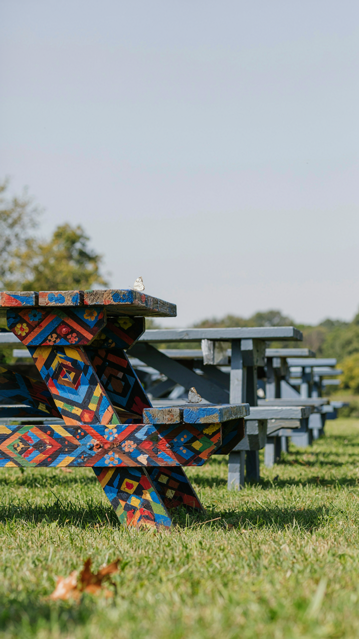 A picnic table with a unique, hand-painted geometric design.