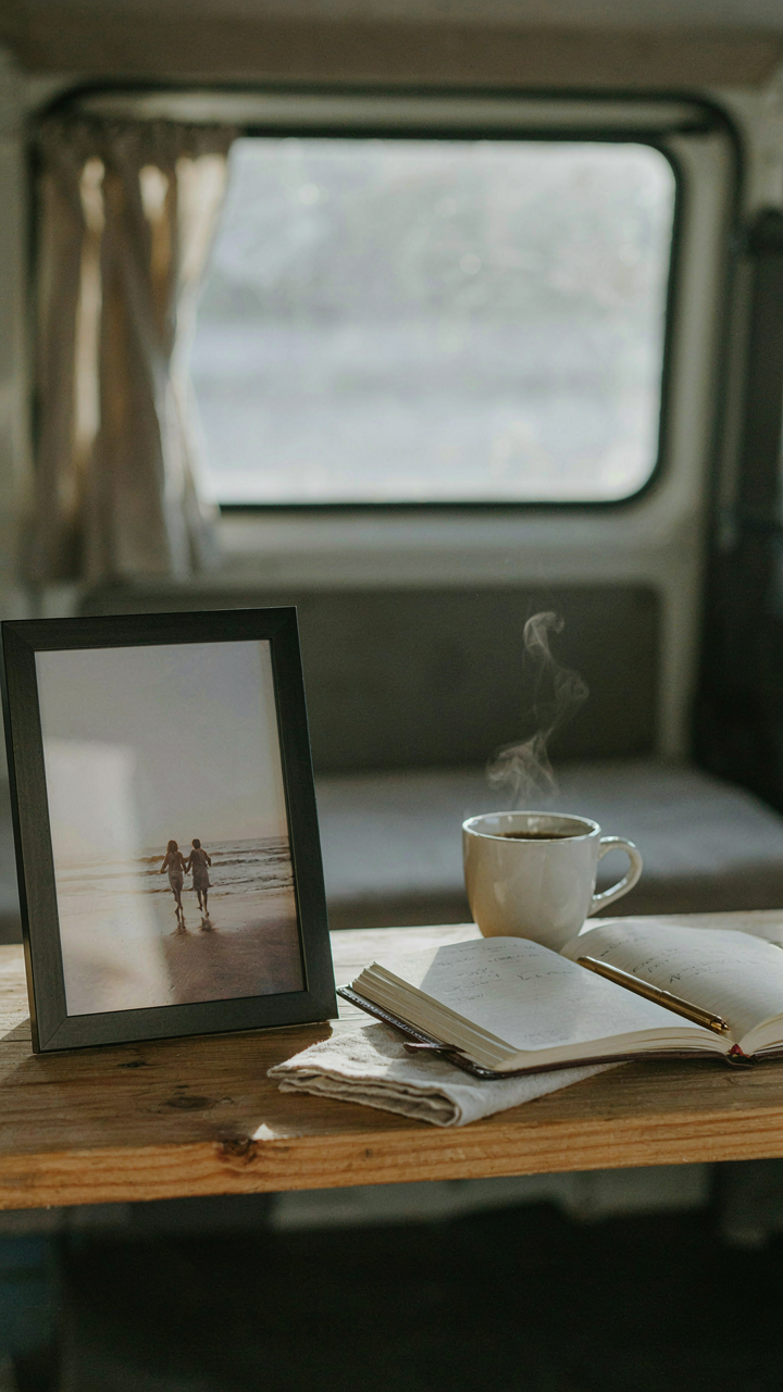 A single framed photo and an open journal displayed on a shelf in a van.
