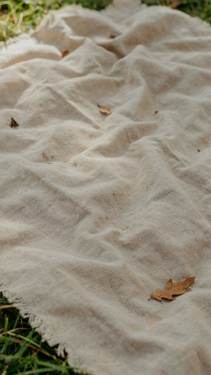 A slightly wrinkled linen picnic blanket shows its soft texture.