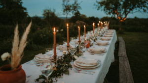 A beautiful outdoor picnic table set for a formal dinner party.