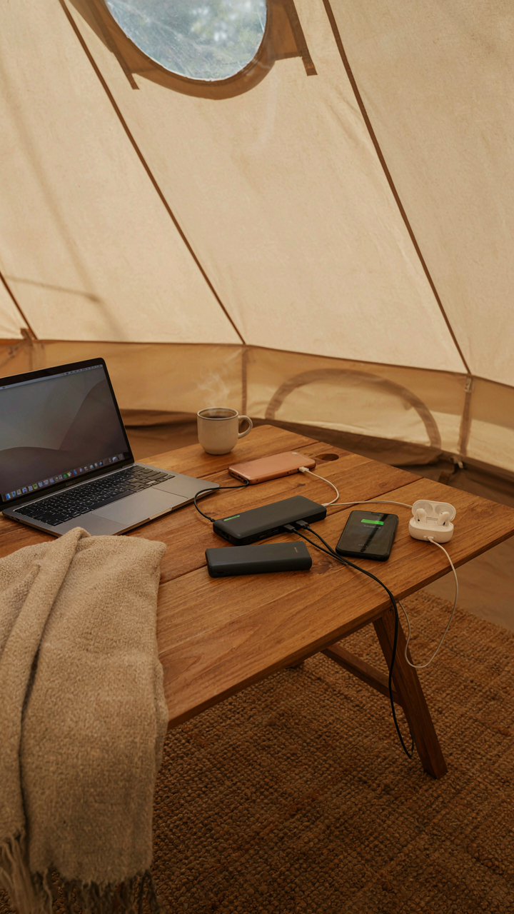 A glamping tent power station with fully charged devices and a power bank.