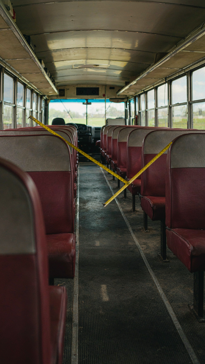 A measuring tape shows the length of an empty school bus interior.
