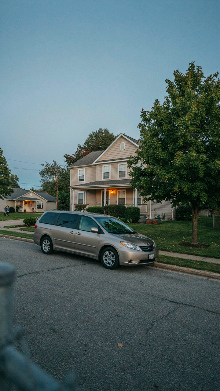 An unassuming minivan parked discreetly on a suburban street.