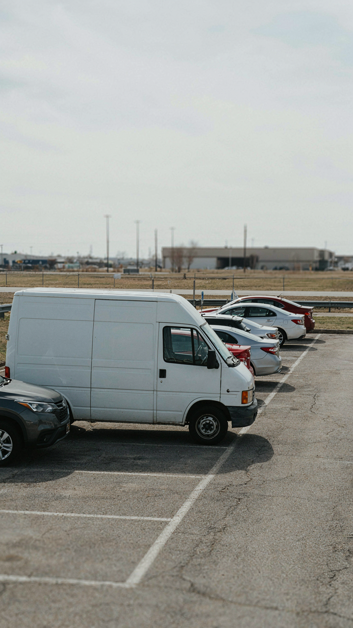 An unmarked white van is parked discreetly in a busy lot.