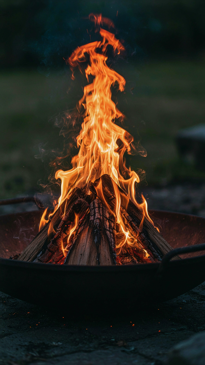 Clean, orange flames burn with little smoke in a metal fire pit.