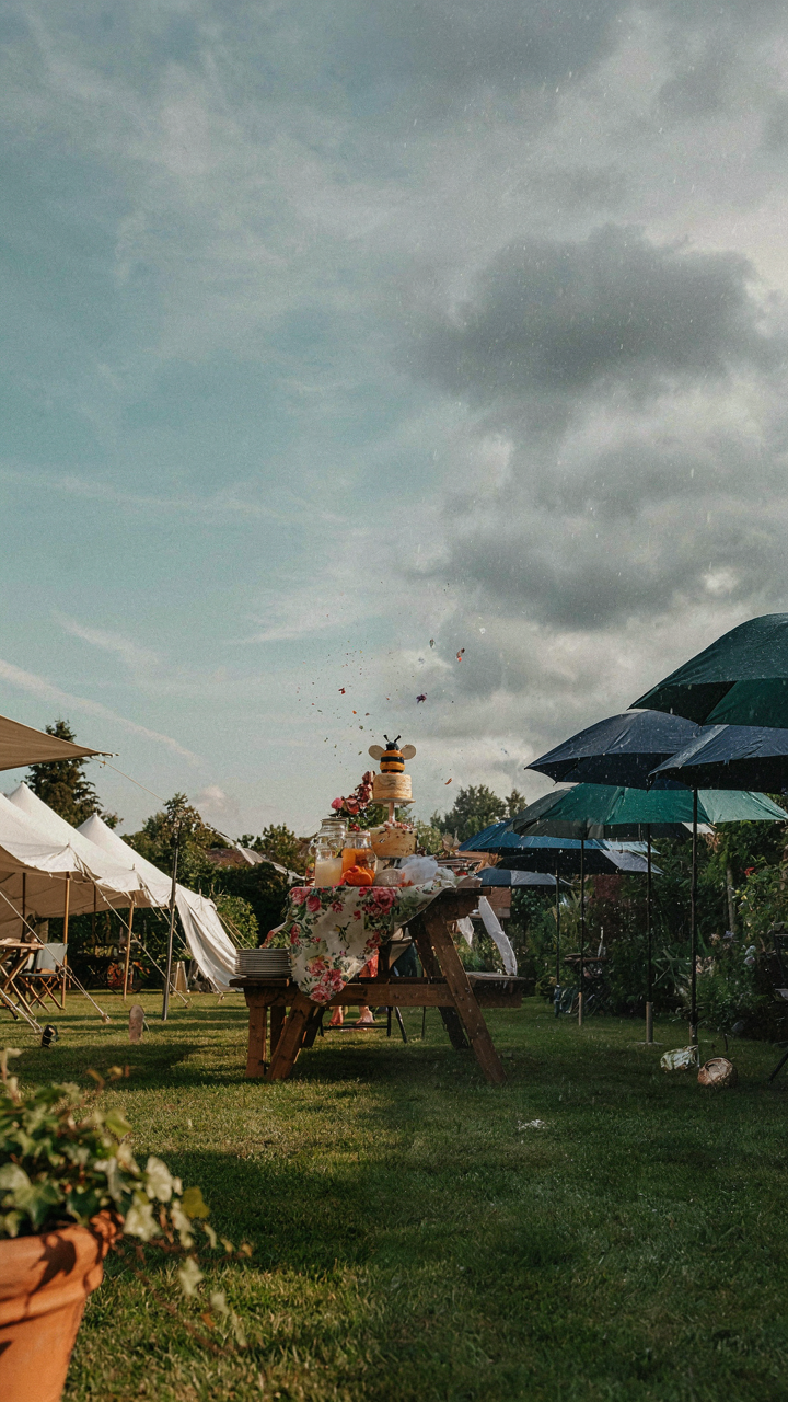 A garden party with tents and umbrellas, ready for sun or rain.