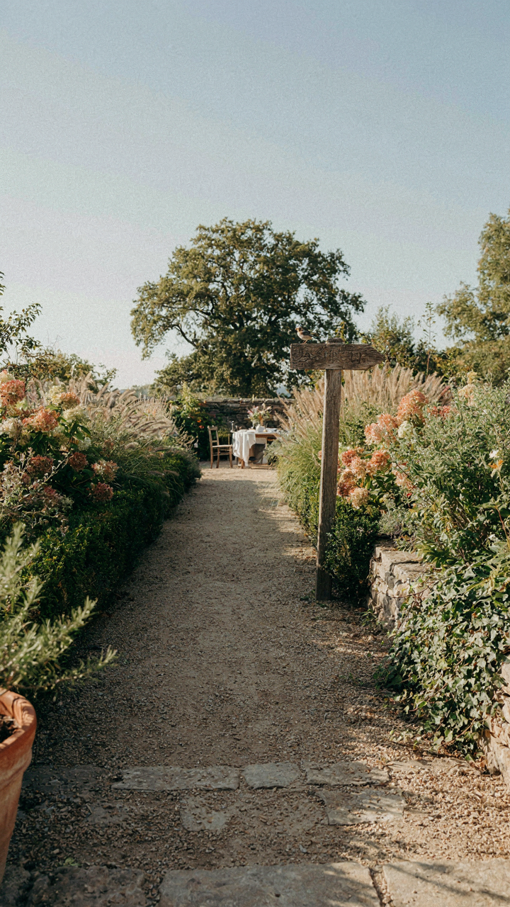 A clear signpost in a garden points the way to a dining area.