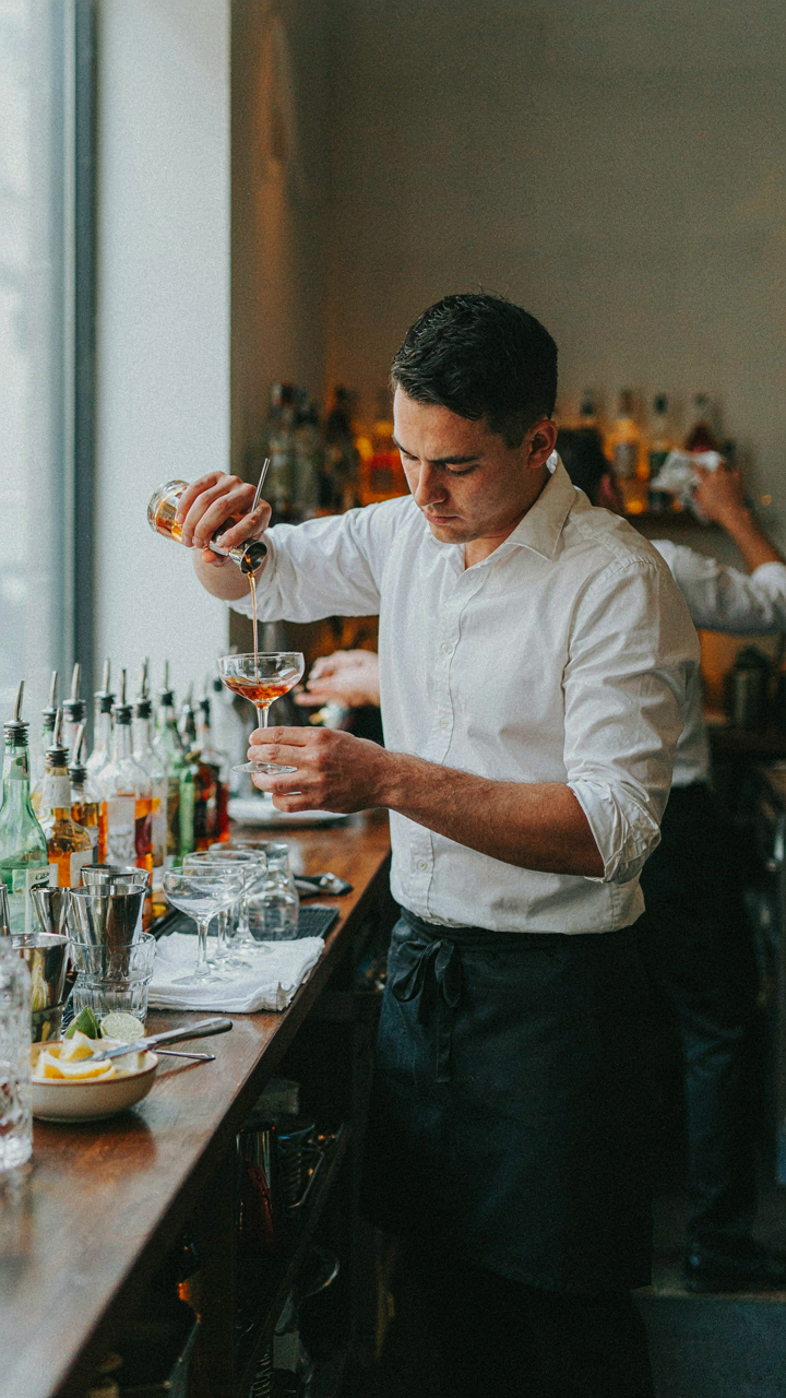 A person quickly makes a drink, like a worker on a factory line.