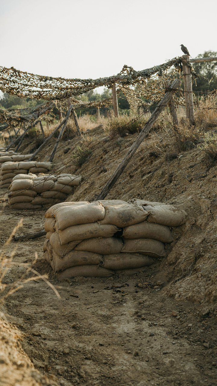 A military-style layered defense with sandbags and a fence.